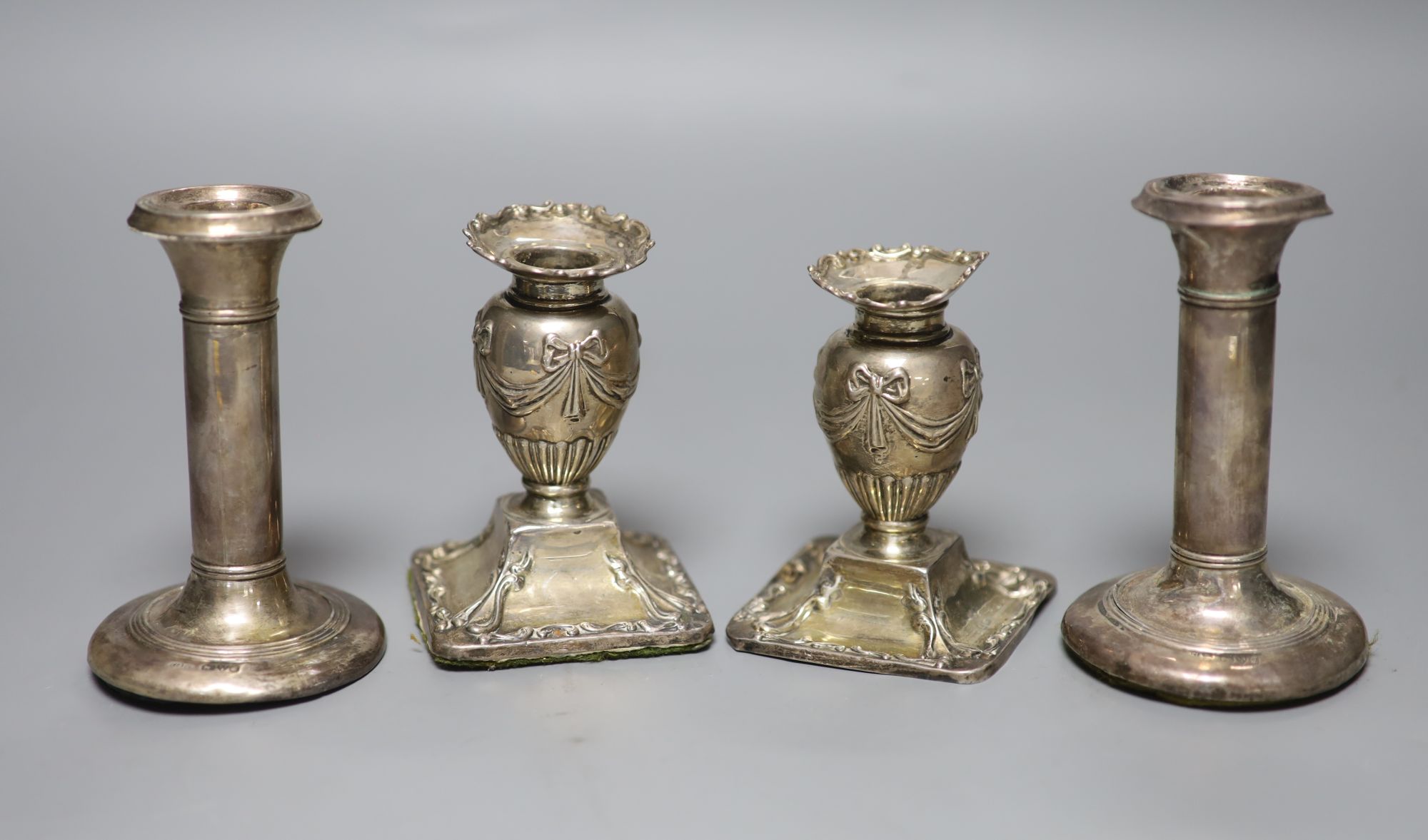 Two pairs of Edwardian silver dwarf candlesticks (a.f.), 11.5cm et infra.